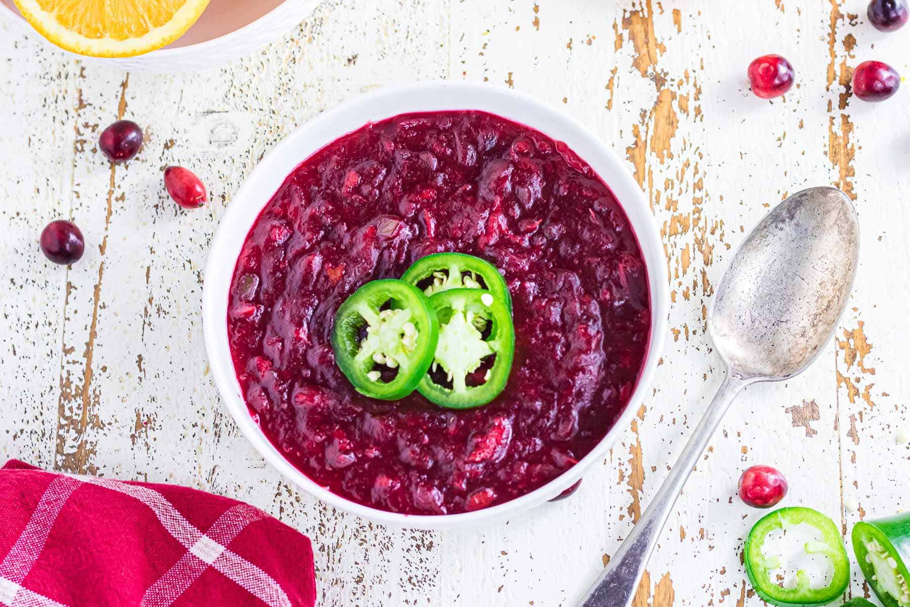 Overhead view of cranberry sauce with sliced jalapenos garnishing the top.