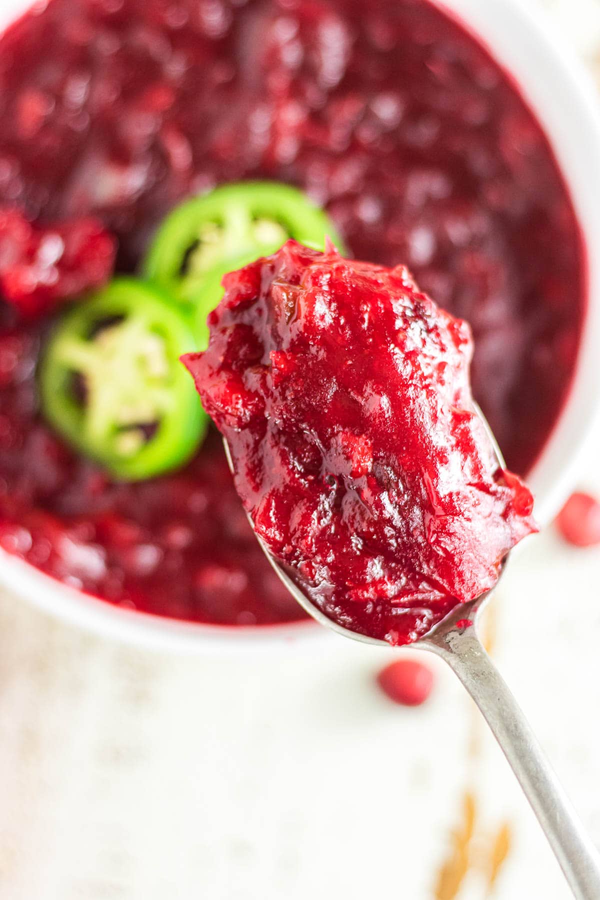 A close-up photo of a spoonful of jalapeno cranberry sauce.