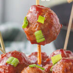 Cranberry sauce meatballs on a toothpick with a title text overlay for Pinterest.