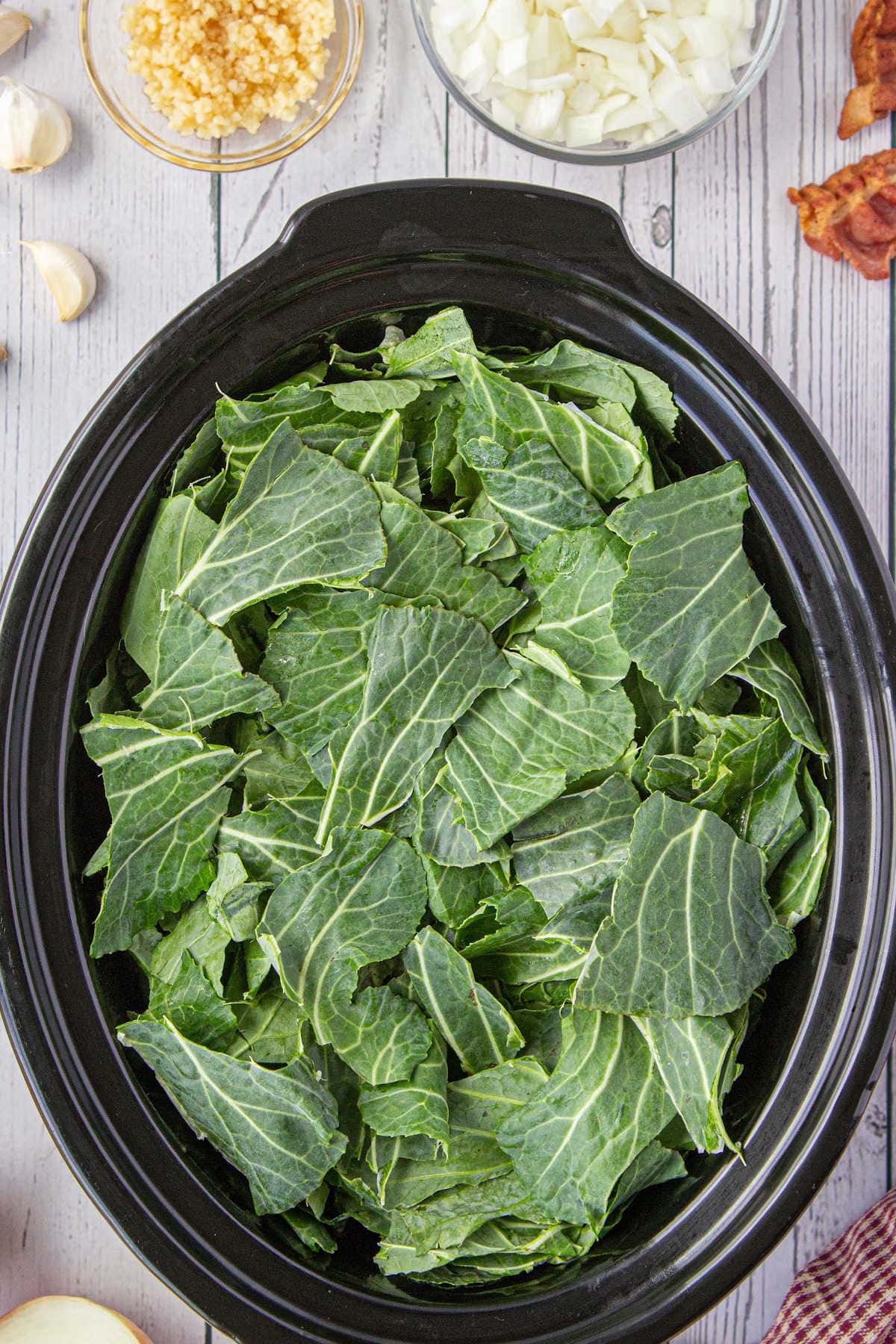 Raw collard greens in a slow cooker.