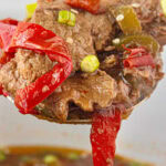 Slow cooker pepper steak being served. Image has a title text overlay for Pinterest.