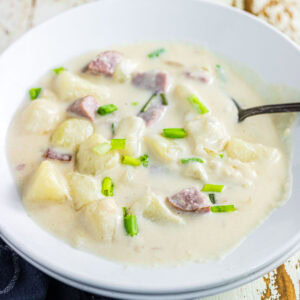 Overhead view of smoked sausage potato soup in a white bowl.