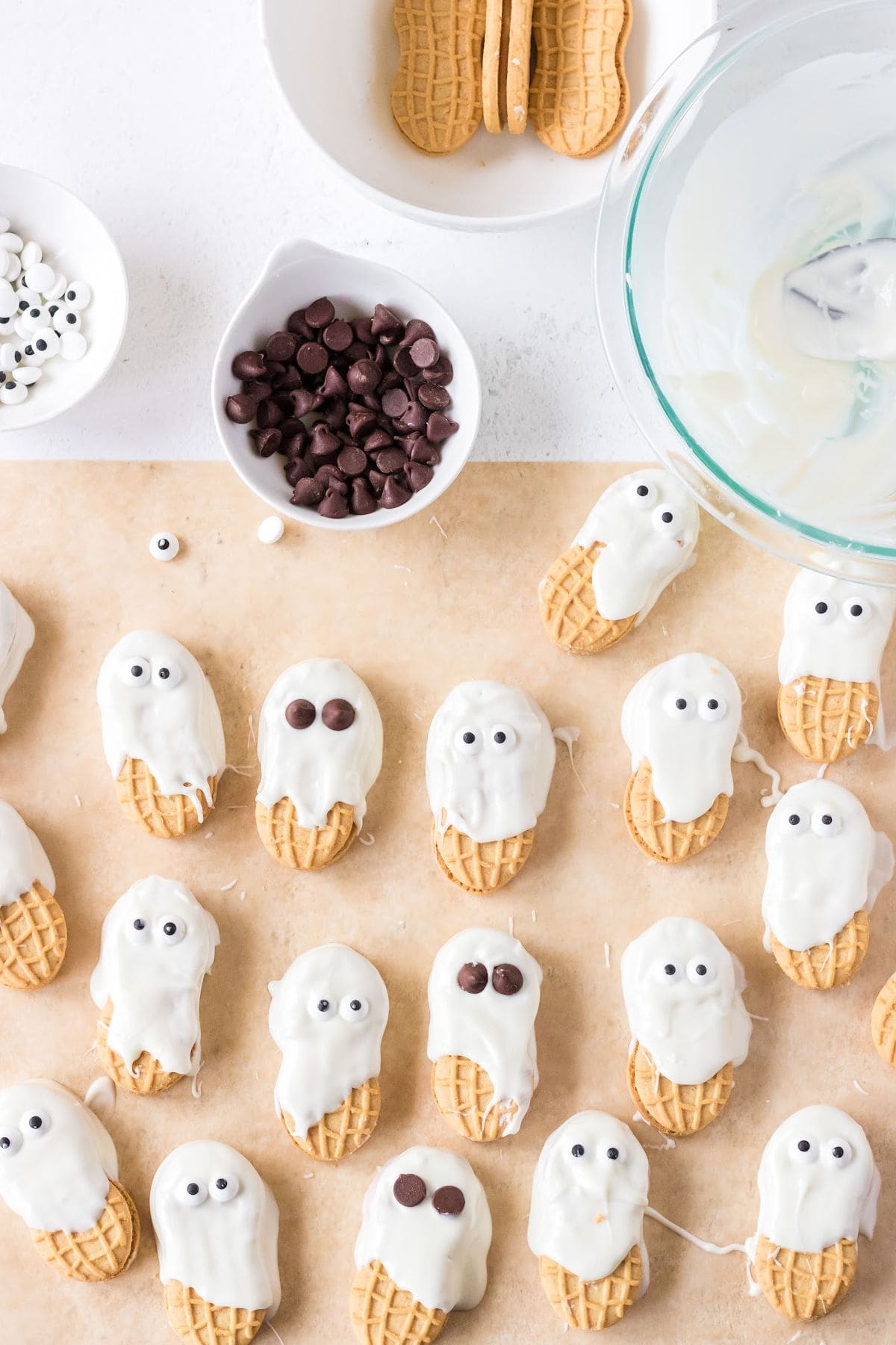 Several cookie "ghosts" on parchment paper.