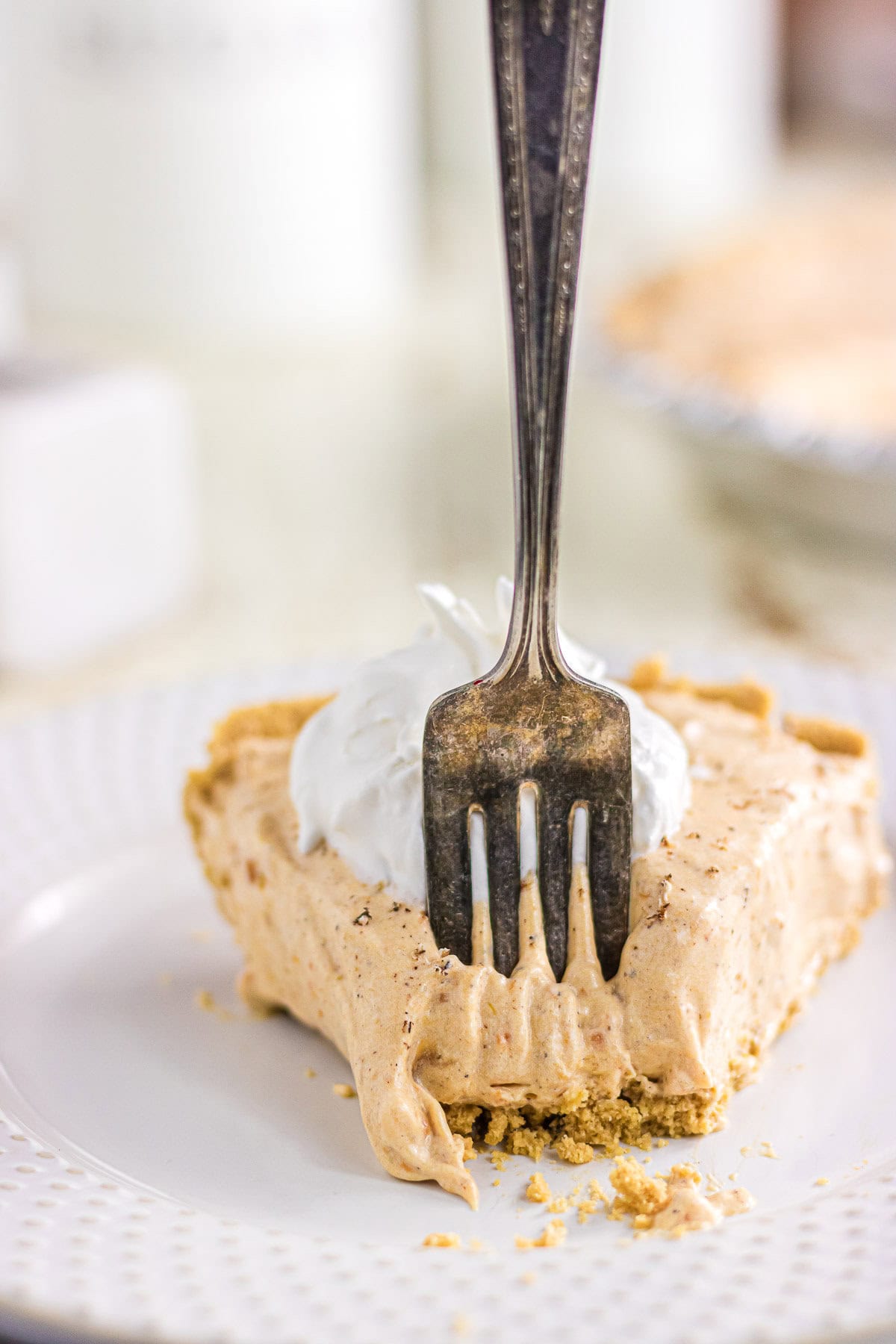 A fork pressed into a slice of no bake sweet potato icebox pie.