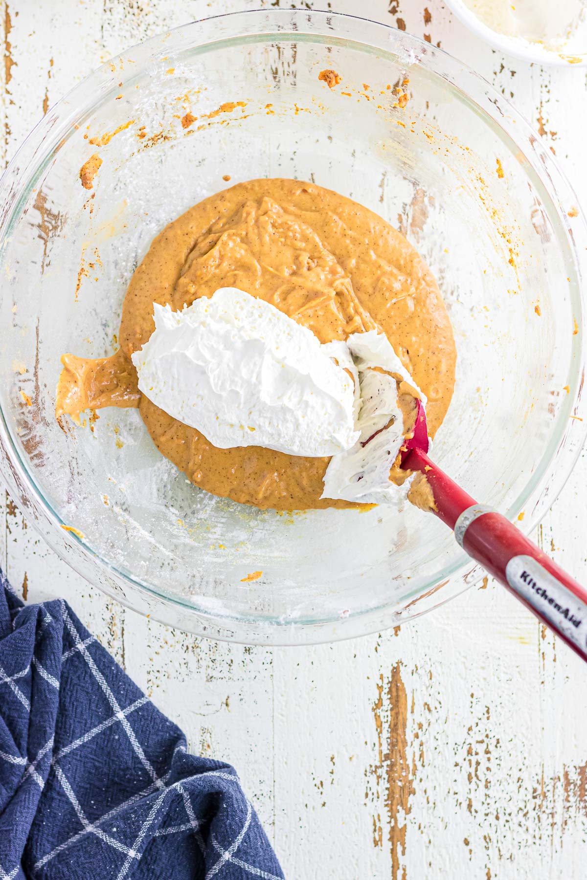 Folding the Cool Whip into the pie filling.