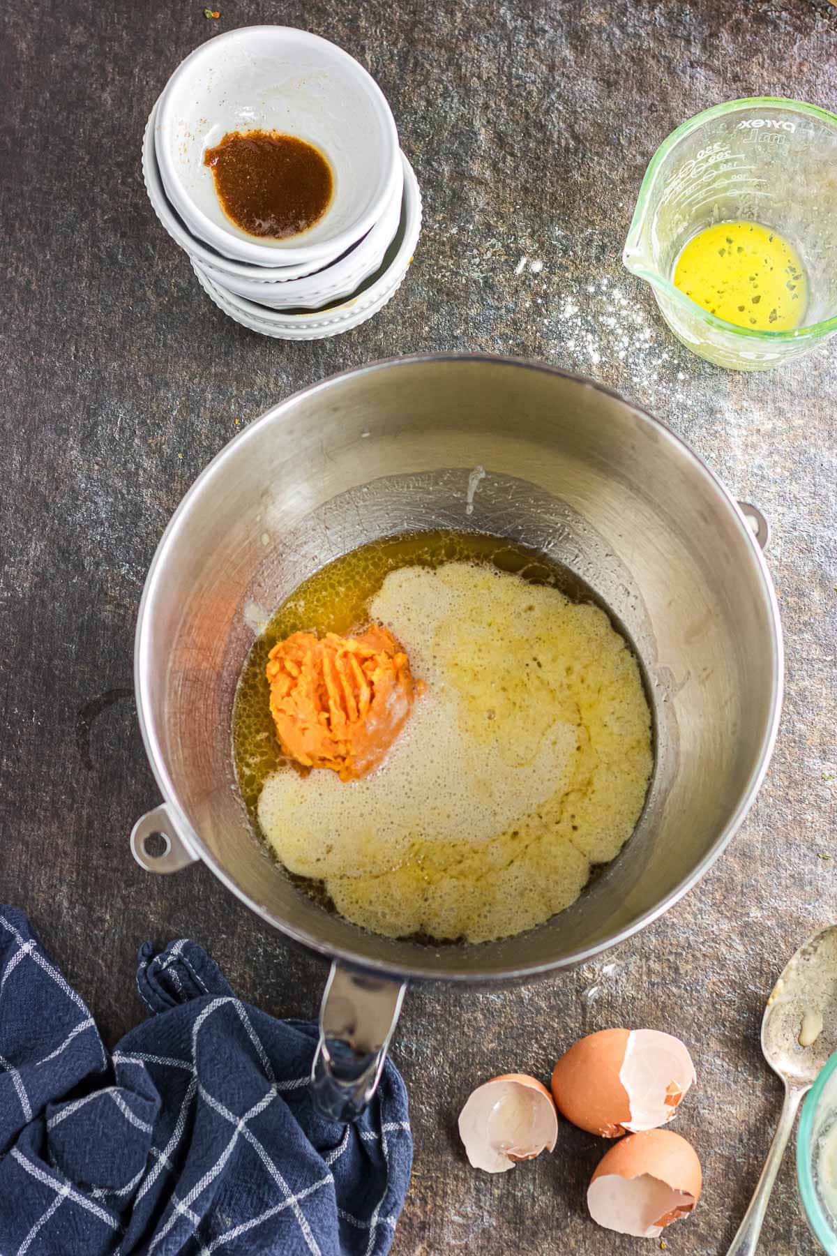 The yeast, water, sugar, sweet potato, butter, salt, and eggs in a mixing bowl.