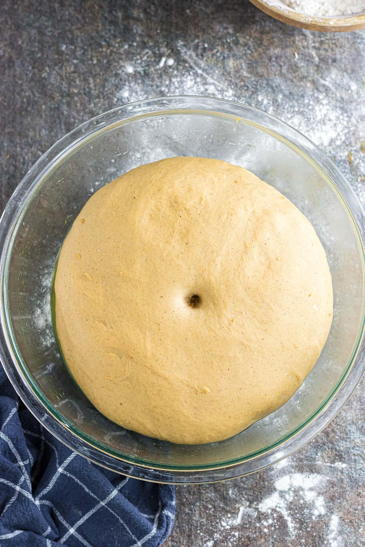 The dough shown risen, doubled in size, in an oiled glass bowl.