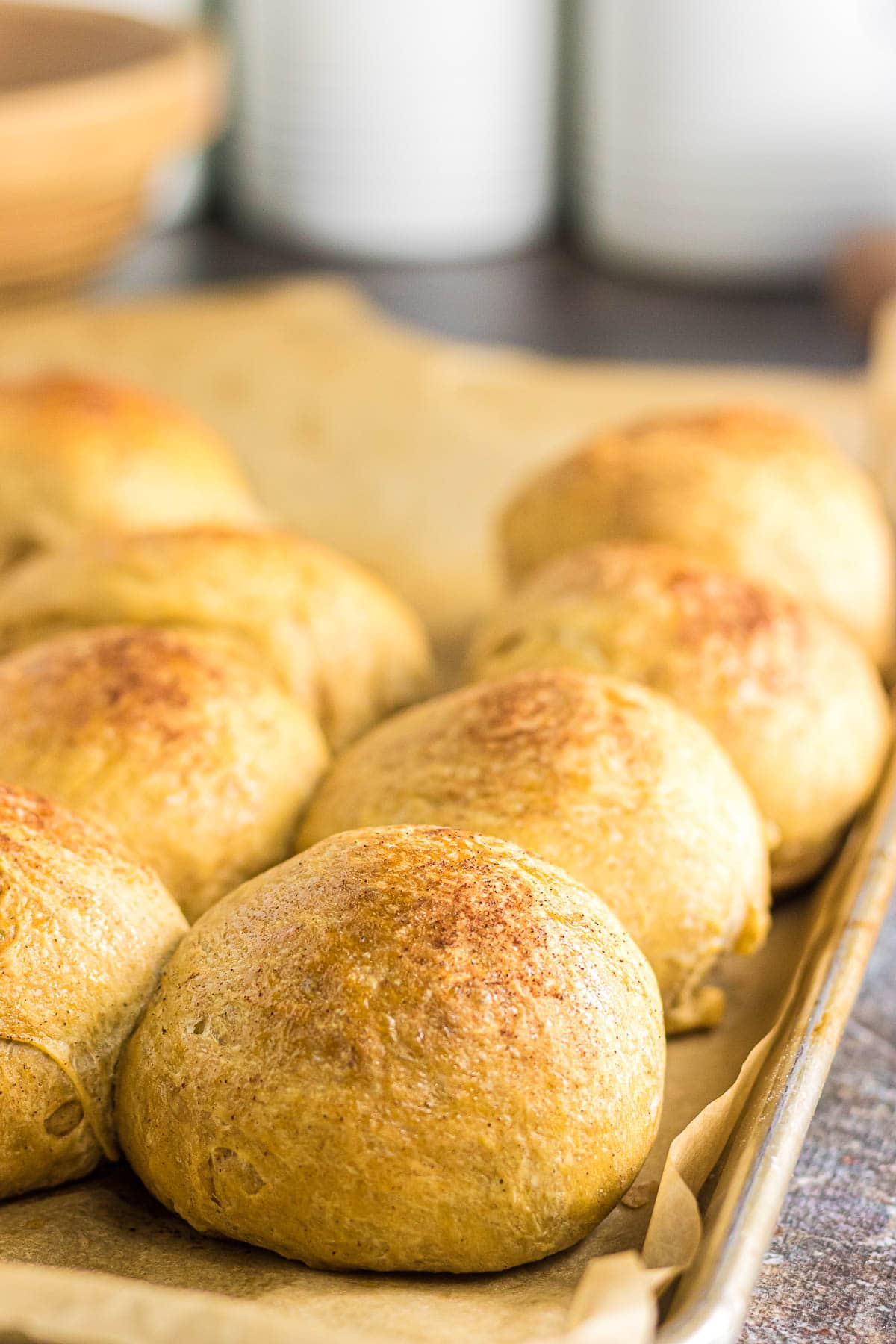 A close-up photo showing the sides of the sweet potato dinner rolls brushed with cinnamon honey glaze.