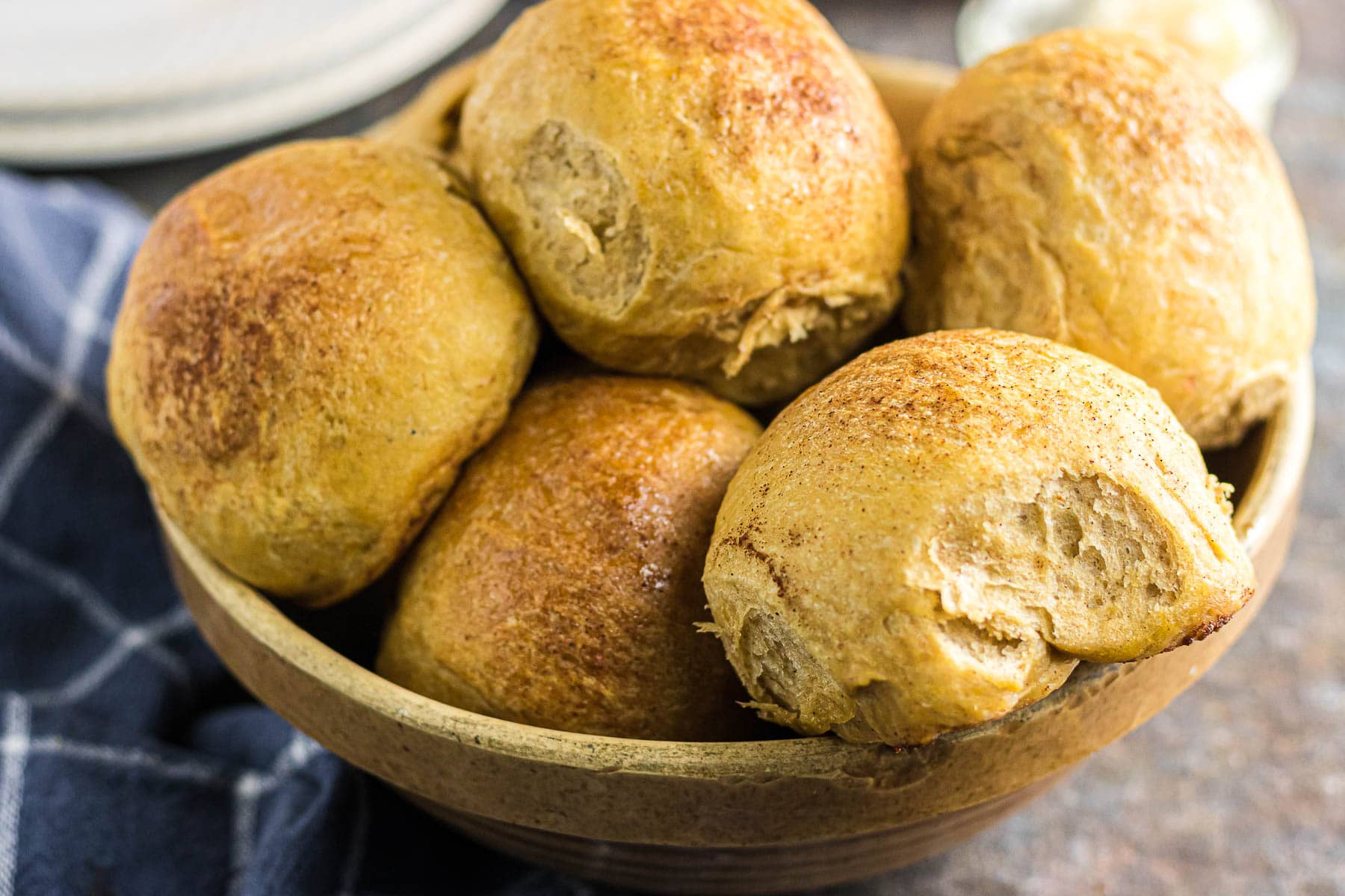 Closeup of sweet potato dinner rolls in a bowl.