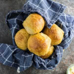 Overhead view of sweet potato dinner rolls in a bowl.