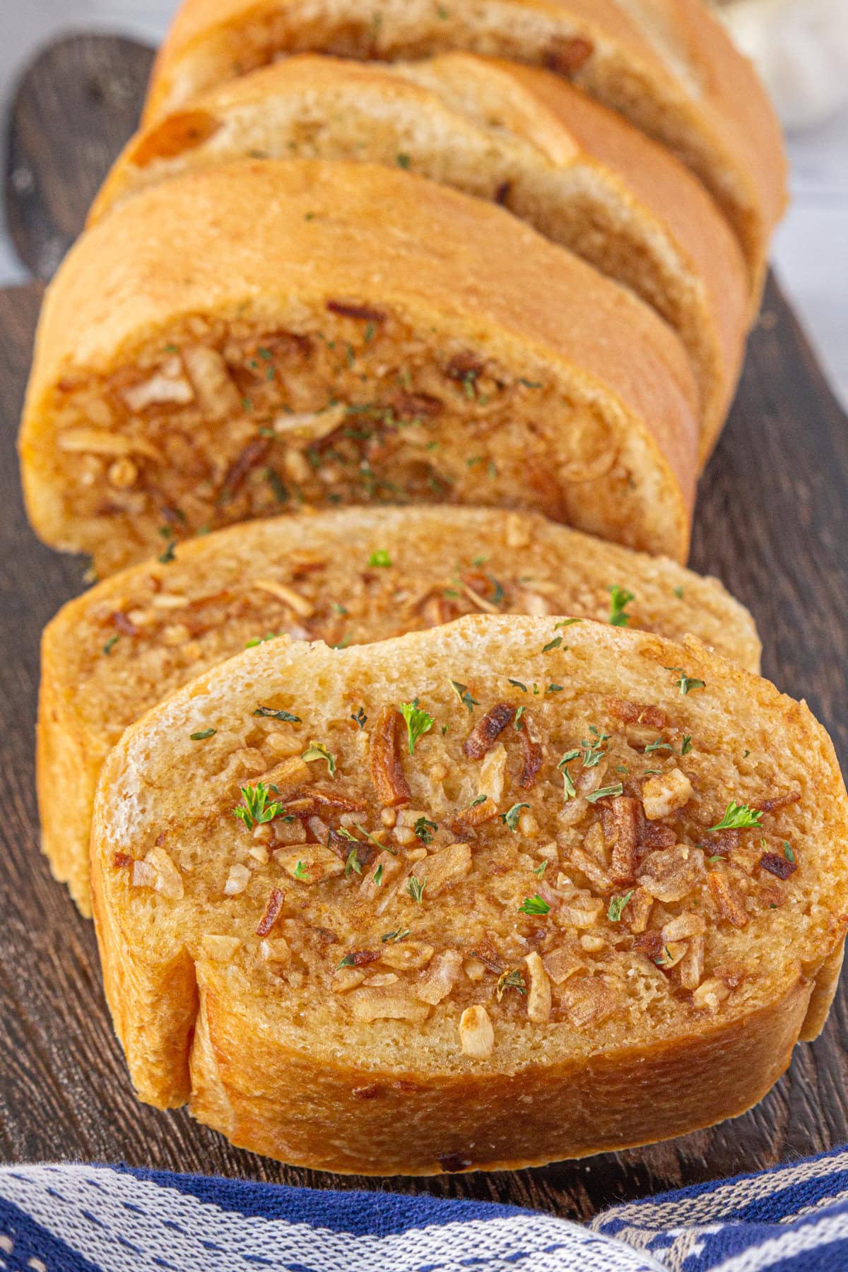 French onion garlic bread sliced on a cutting board.