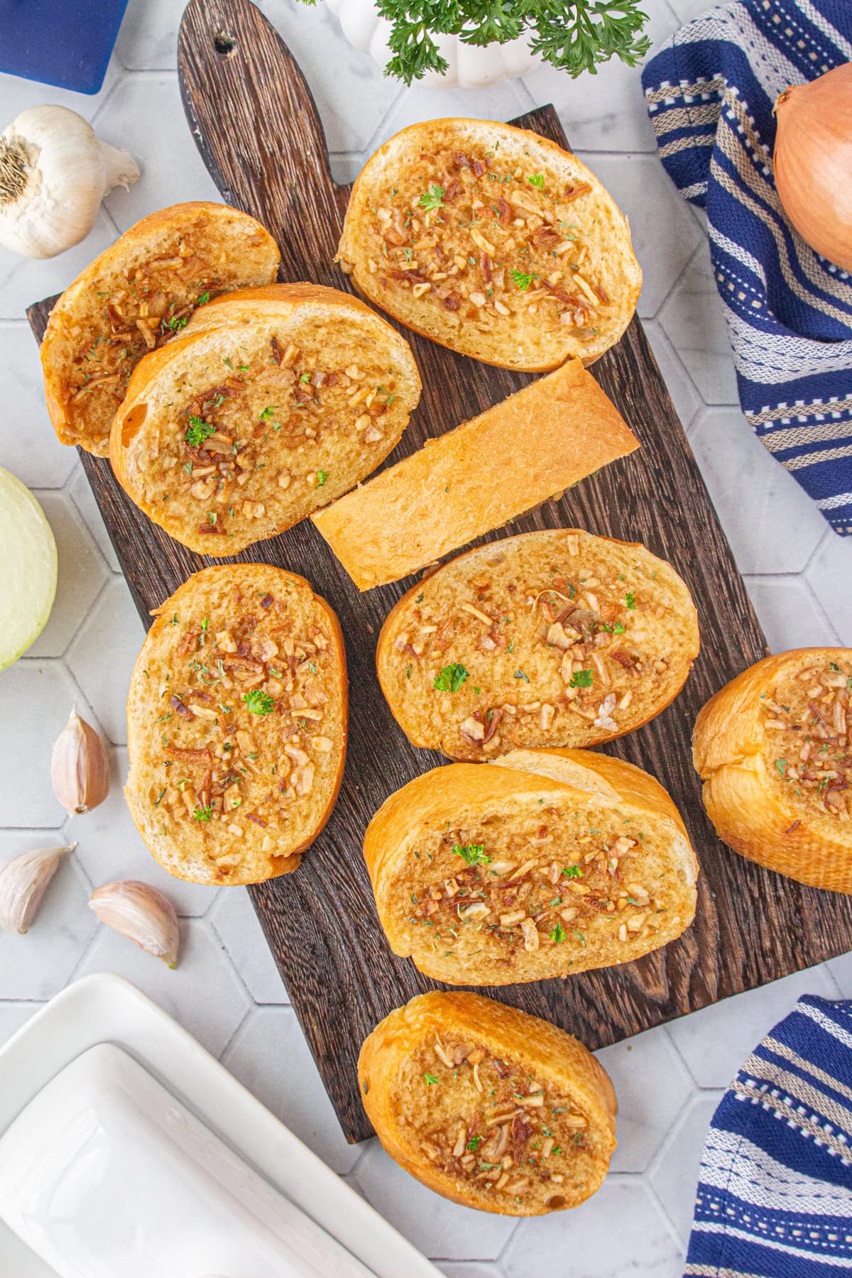 An overhead view of sliced French onion garlic bread on a cutting board.