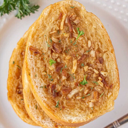 Closeup of French onion garlic bread on a white plate.