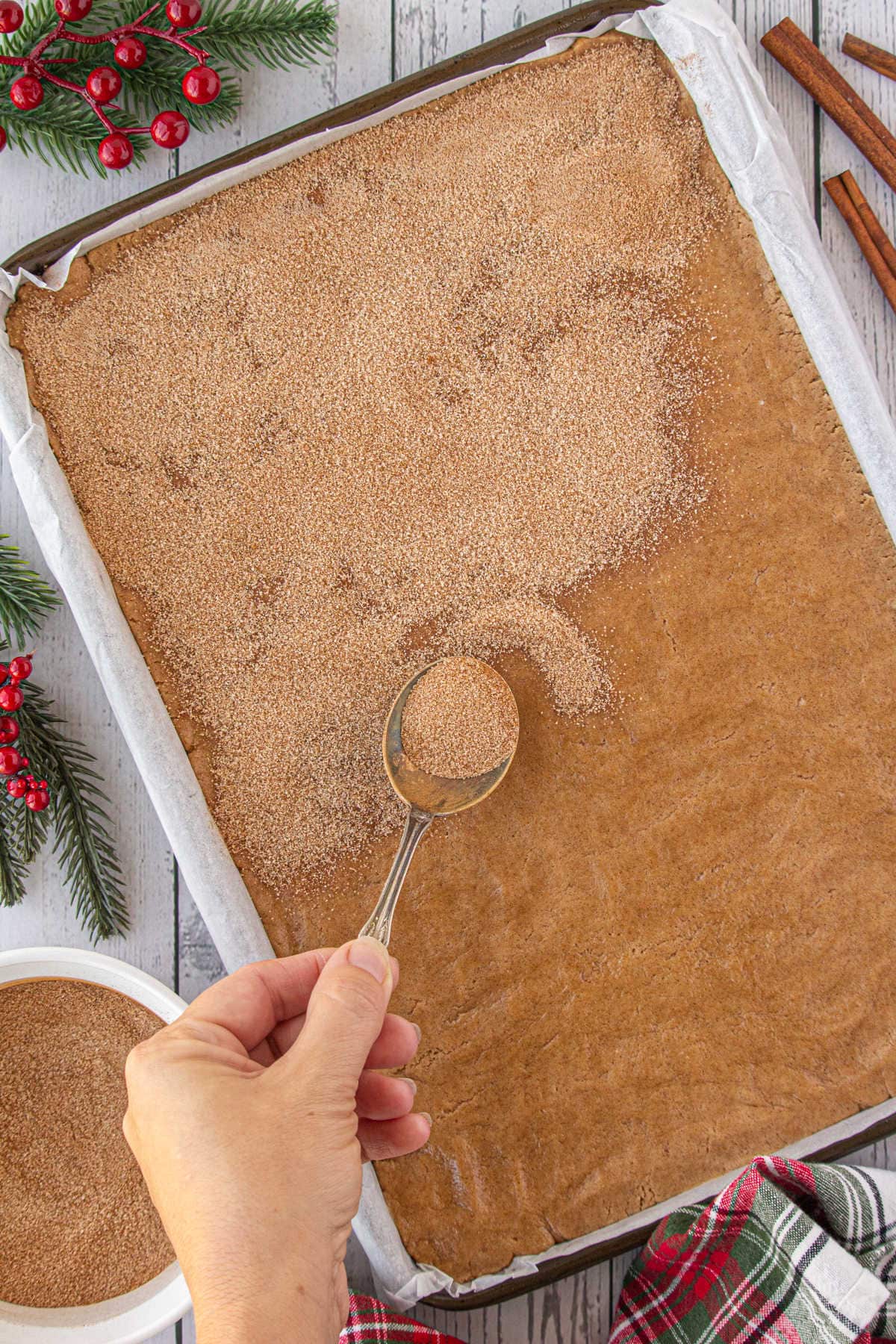 Sprinkling the top of the dough with cinnamon sugar.