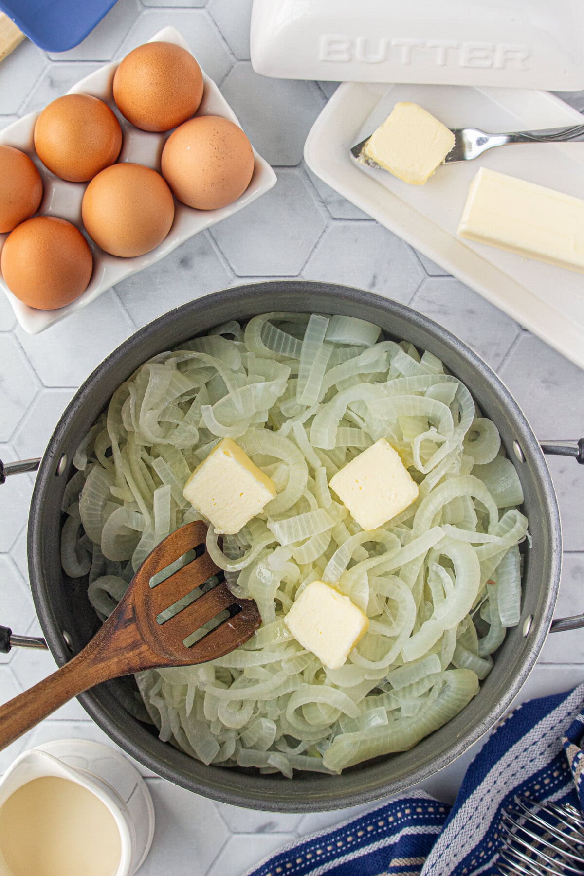 Stirring butter into the drained onions.