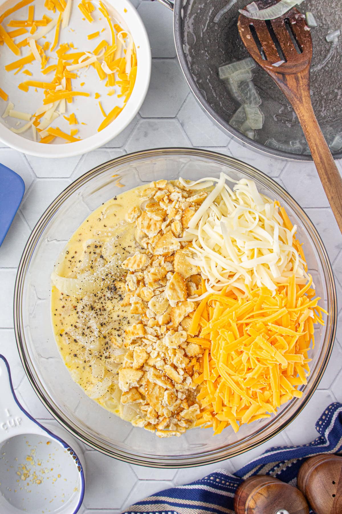 Adding the onions, crackers, and cheese to the mixing bowl.