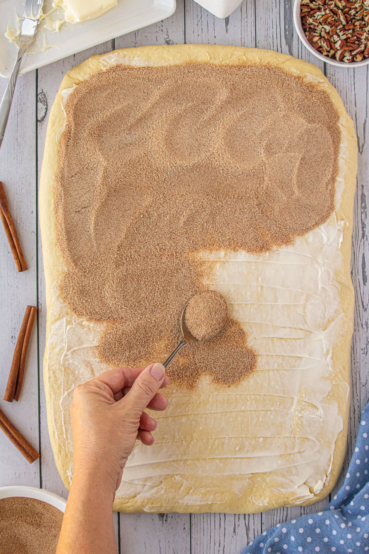 Cinnamon sugar being added over the butter.