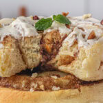 Closeup of a cinnamon roll with a bite removed.