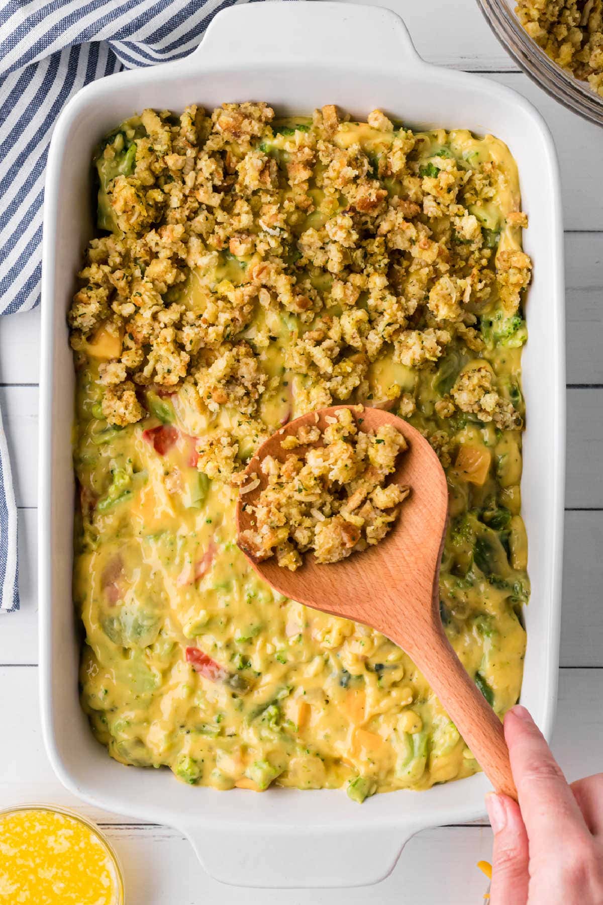 Broccoli mixture has been added to a casserole dish and topped with the stuffing mixture.