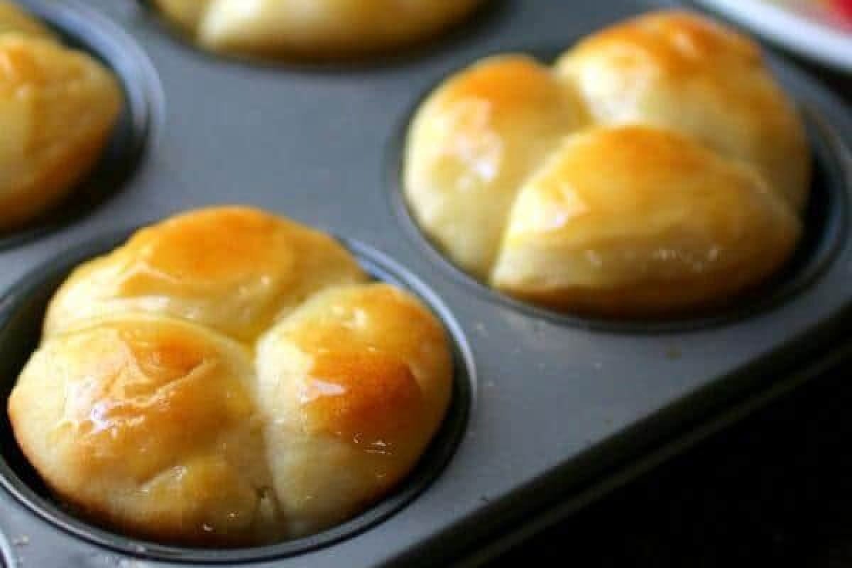 Closeup of cloverleaf rolls in a muffin tin.