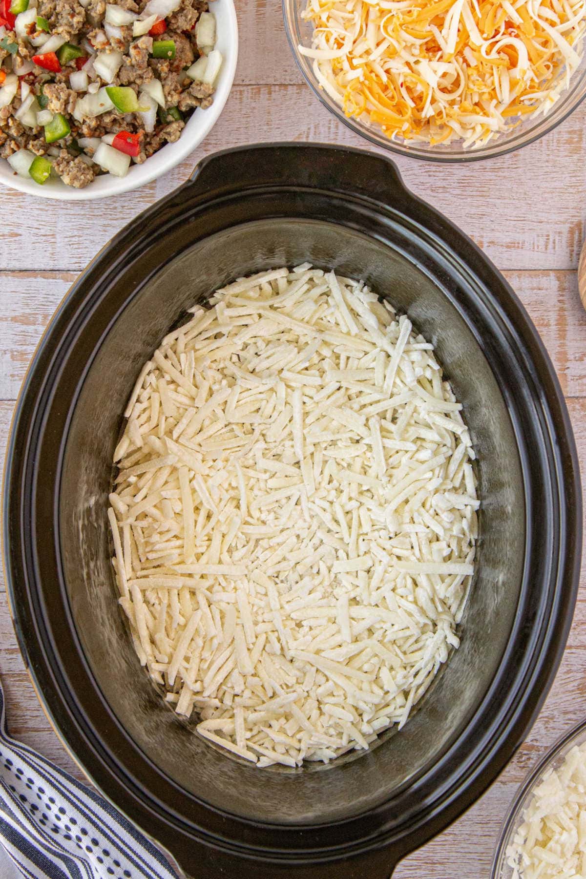 Hashbrown potatoes covering the bottom of the crockpot.