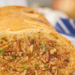 A closeup of French onion garlic bread with a title text overlay for Pinterest.