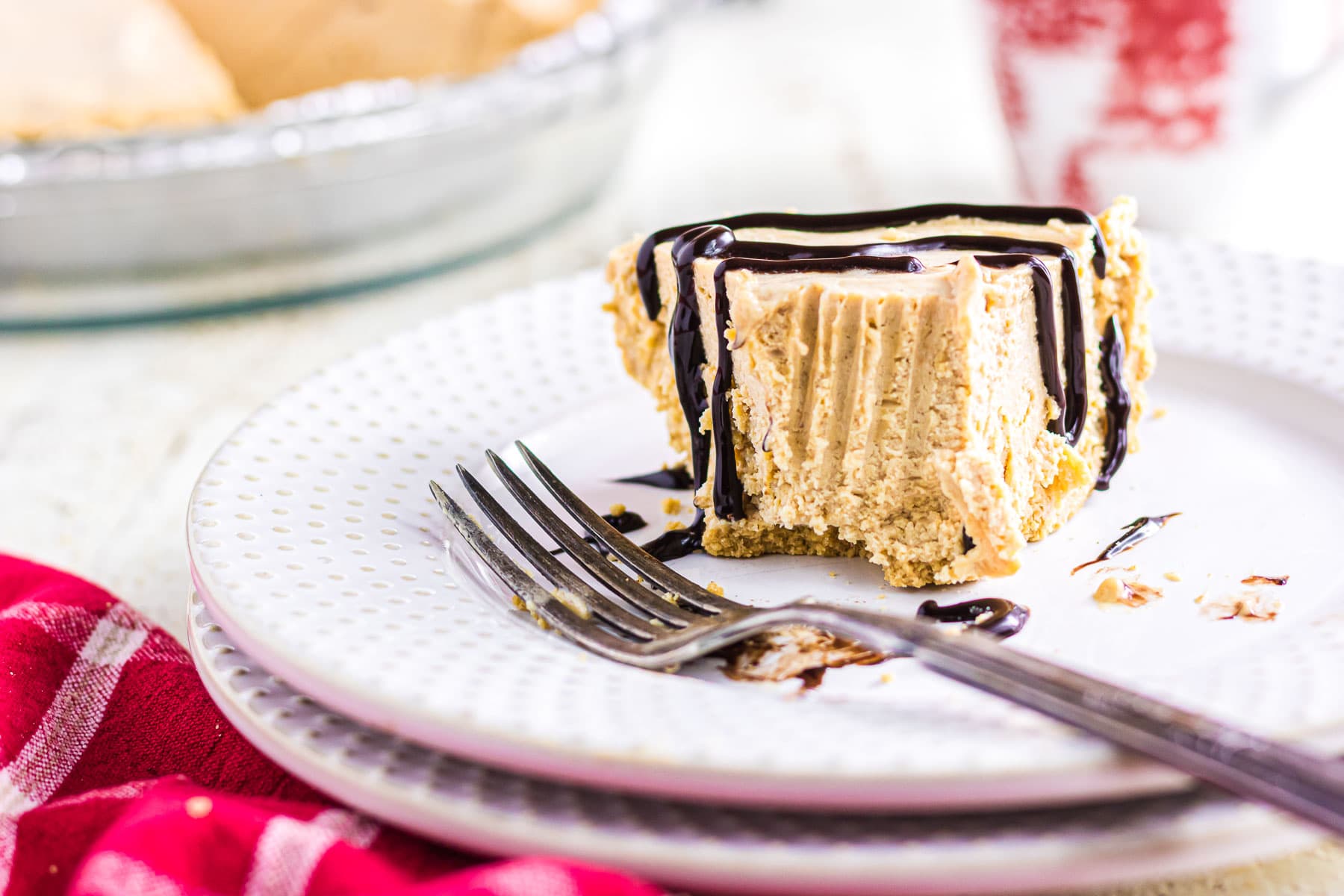 A slice of peanut butter icebox pie with chocolate drizzle.