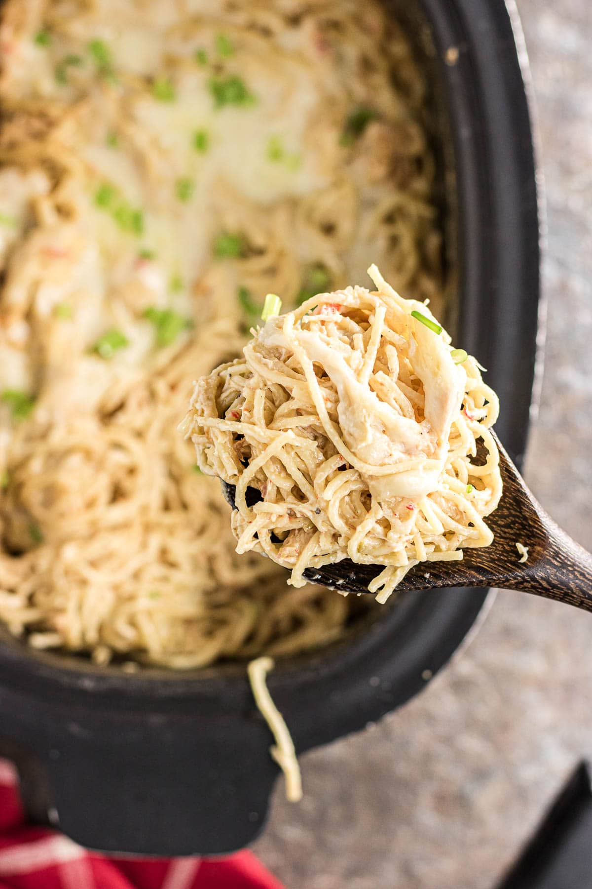 An up-close photo of a scoop of slow cooker chicken tetrazzini on a serving spoon.