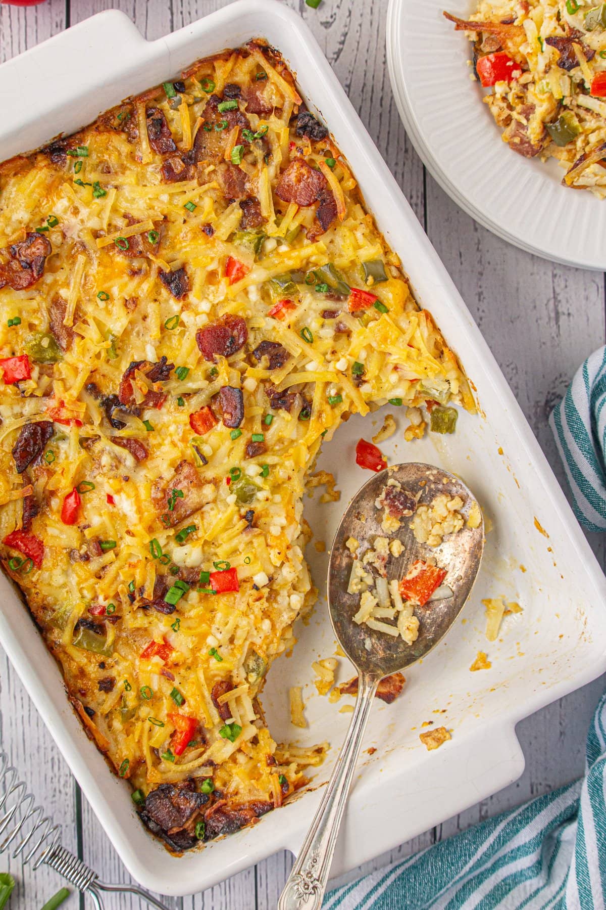 Amish breakfast casserole with a few spoonfuls removed to a serving plate.