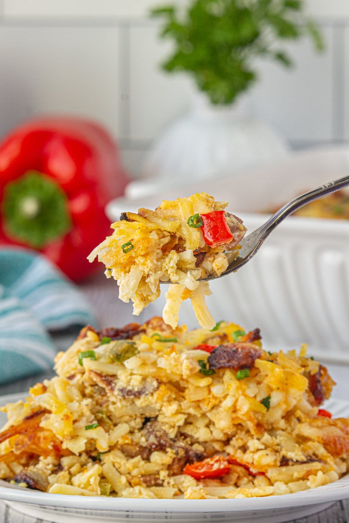 A fork scooping Amish breakfast casserole off a plate.