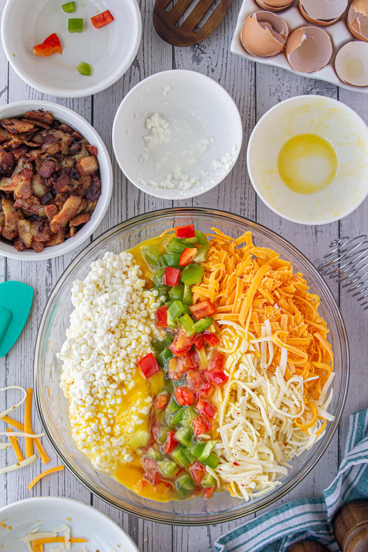 Combining the cheese, cottage cheese, eggs, potatoes, and peppers in a bowl.