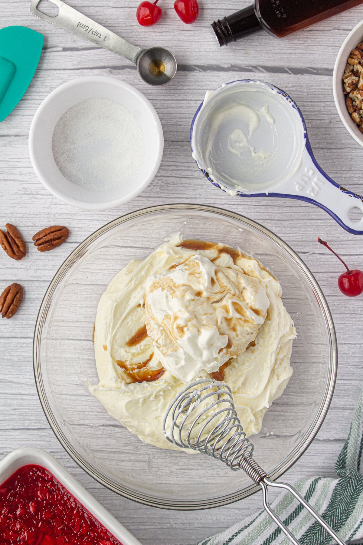 Whisking the sour cream and vanilla into the cream cheese and sugar.