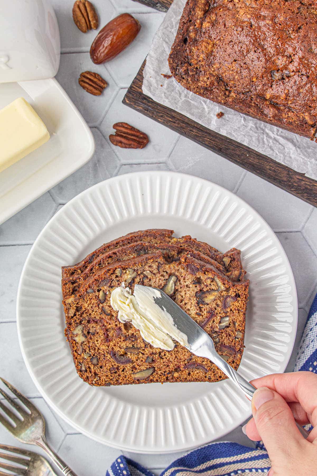 Adding a pat of butter to the date nut bread.