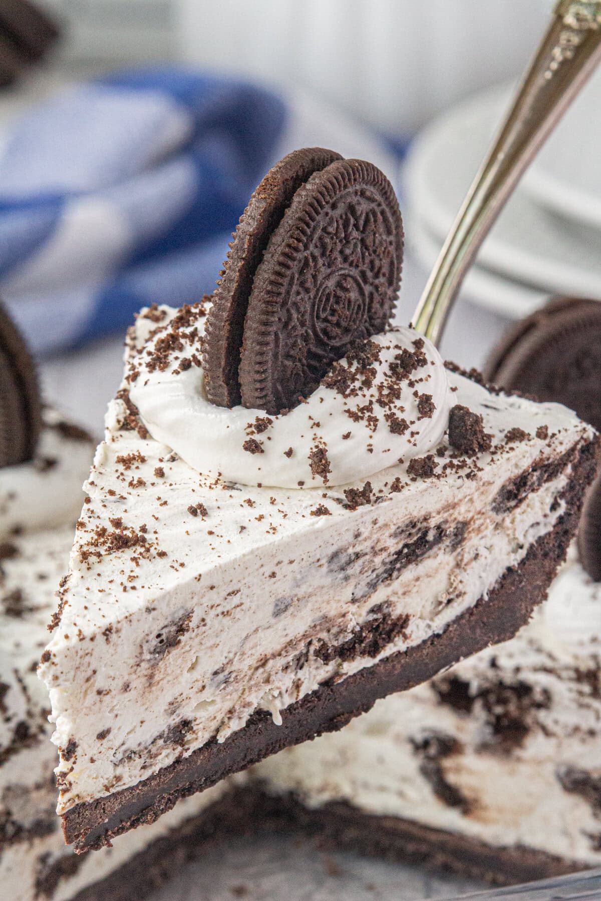 An up-close, angled view of a slice of Oreo icebox pie on a pie server.