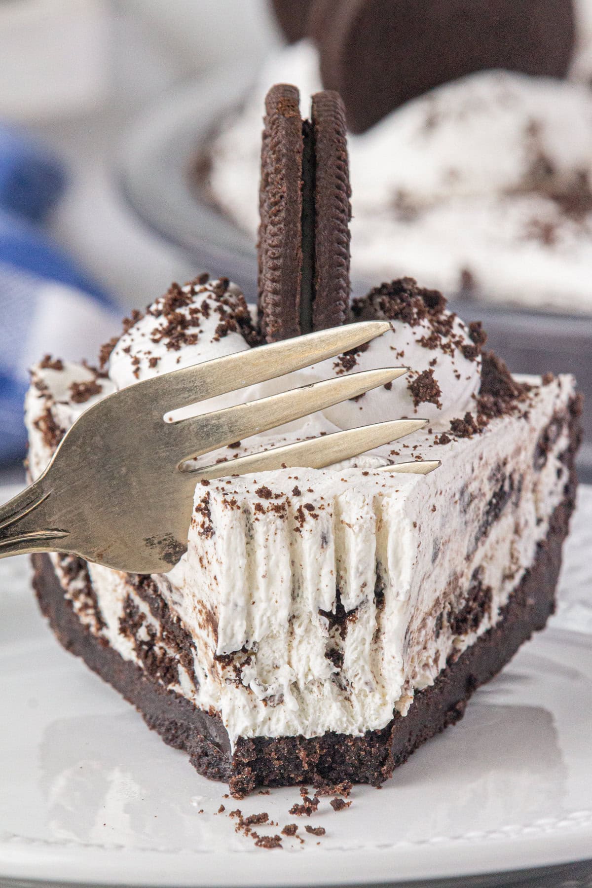 An eye-level view of a slice of Oreo icebox pie with a fork slicing in.