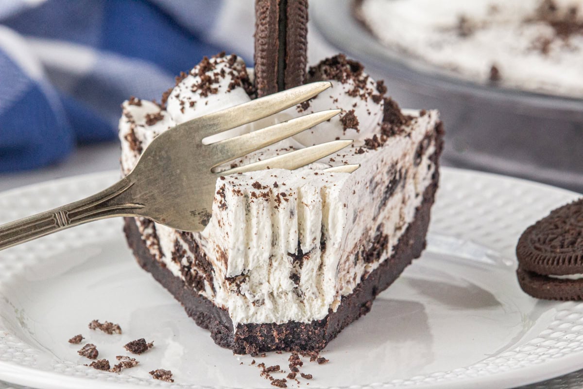 A fork cutting into a slice of Oreo icebox pie.