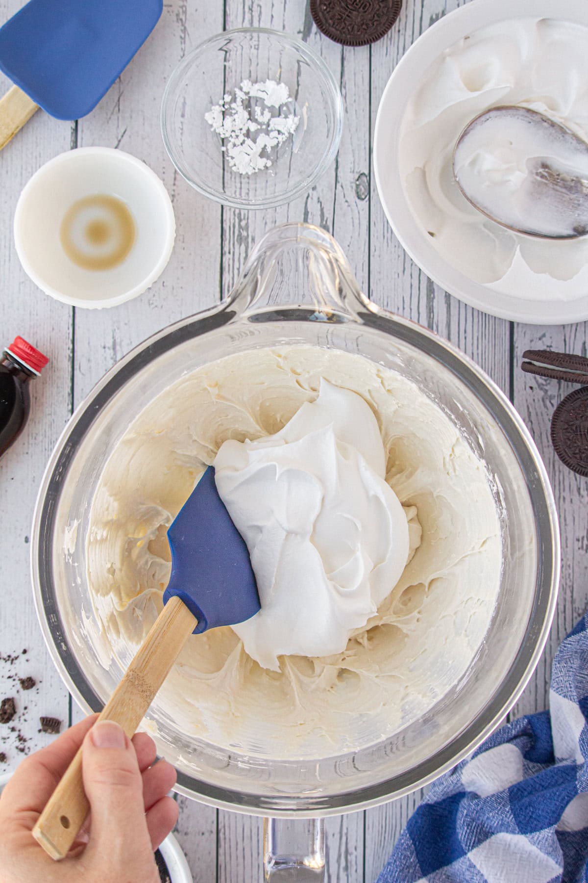 Folding the Cool Whip into the beaten cream cheese, vanilla, and powdered sugar.