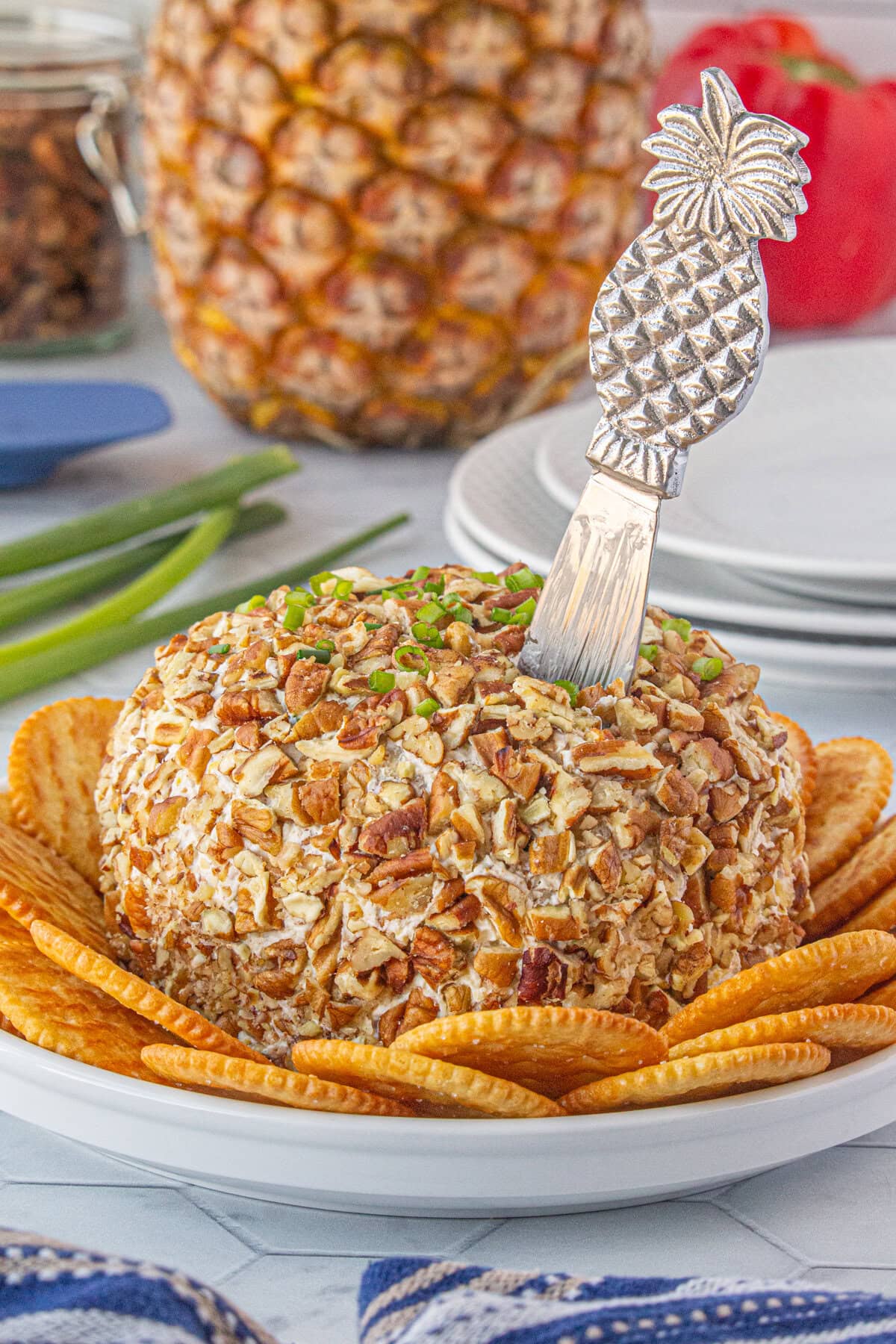 A side-view of the pineapple cheese ball surrounded by crackers.