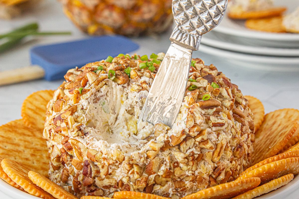 Pineapple pecan cheese ball on a tray with crackers.