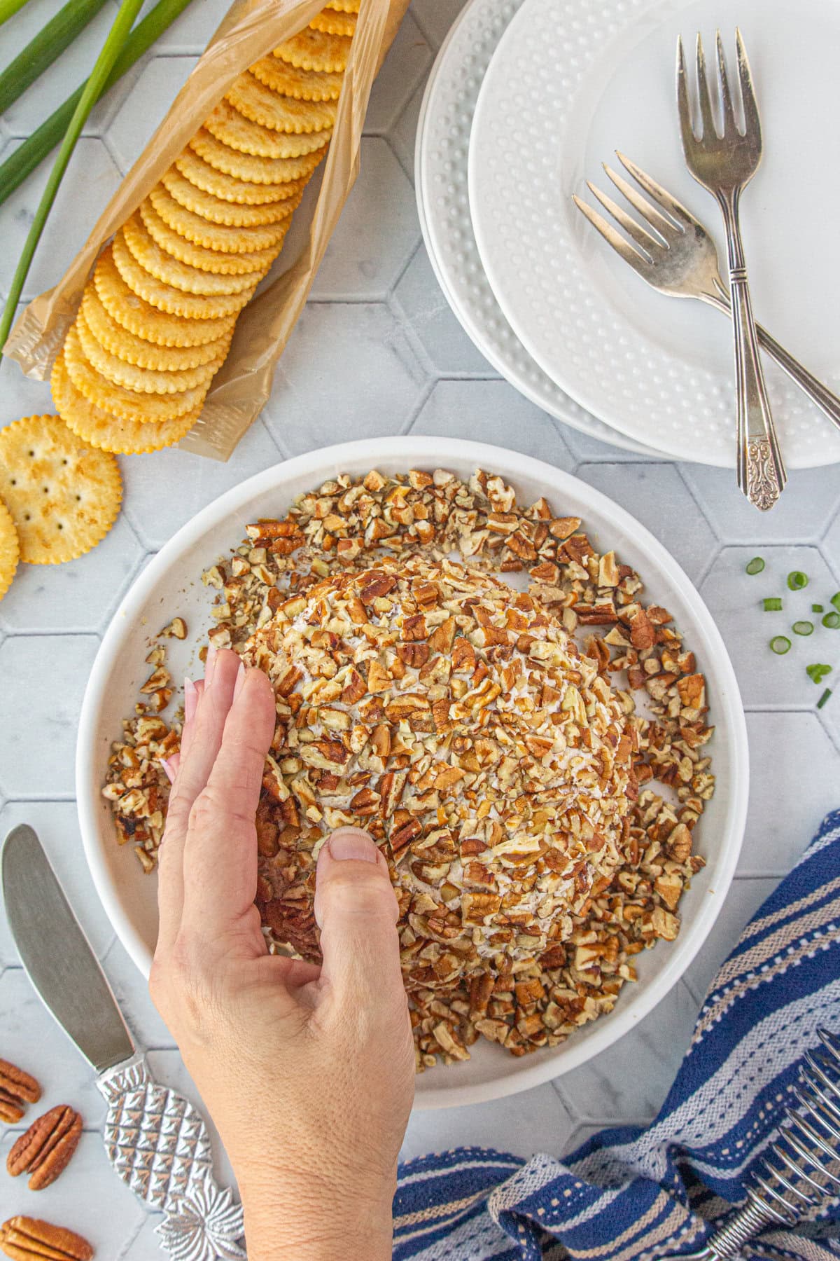 Rolling the cheese ball in pecans.