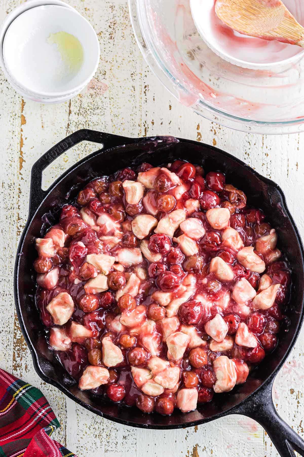 The cherry cream cheese bubble up ingredients spread in a skillet.