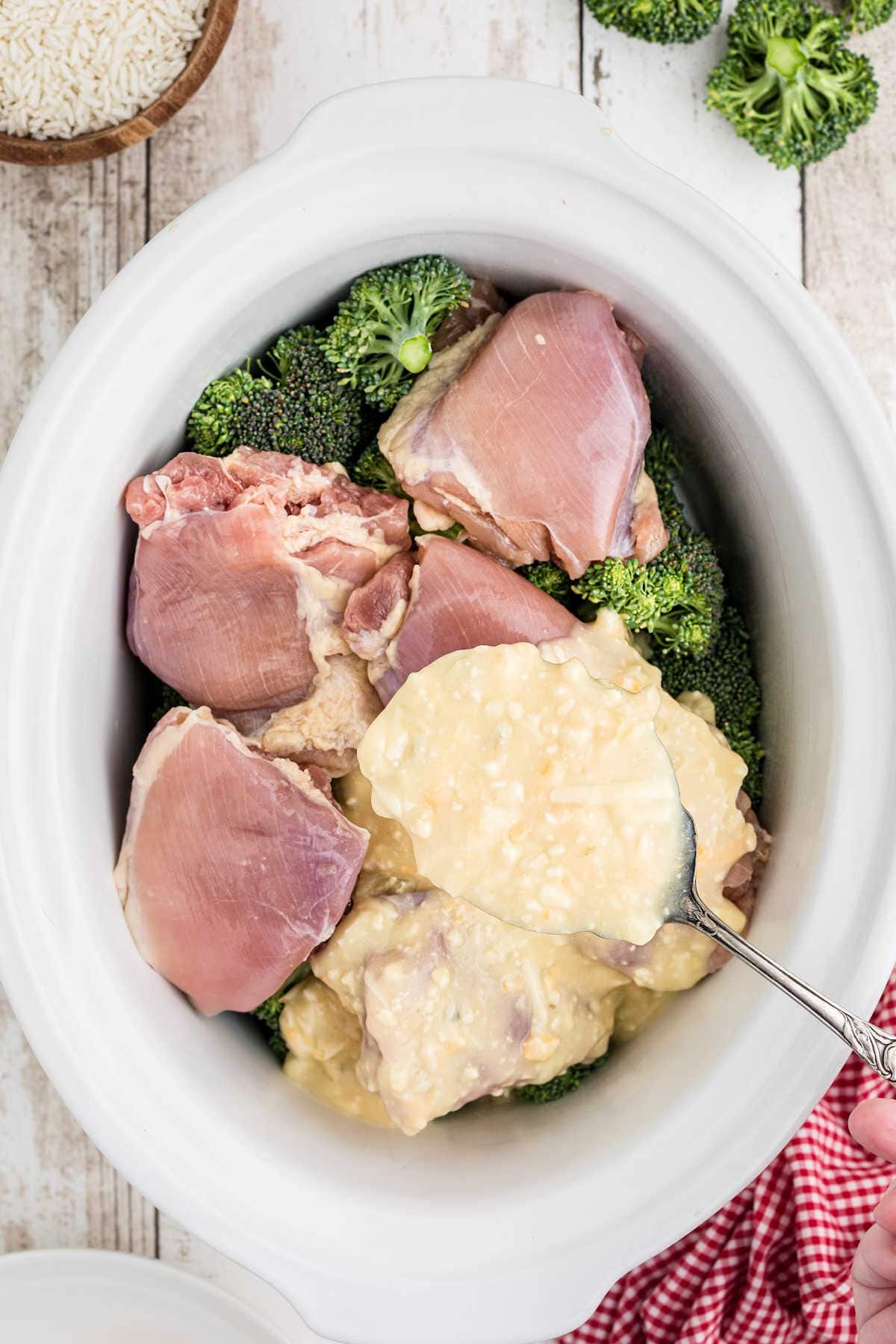 Chicken, broccoli and sauce added to the slow cooker.