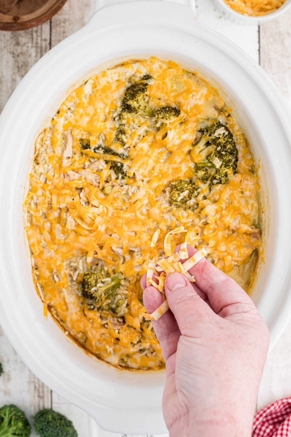 Casserole being topped with cheese.