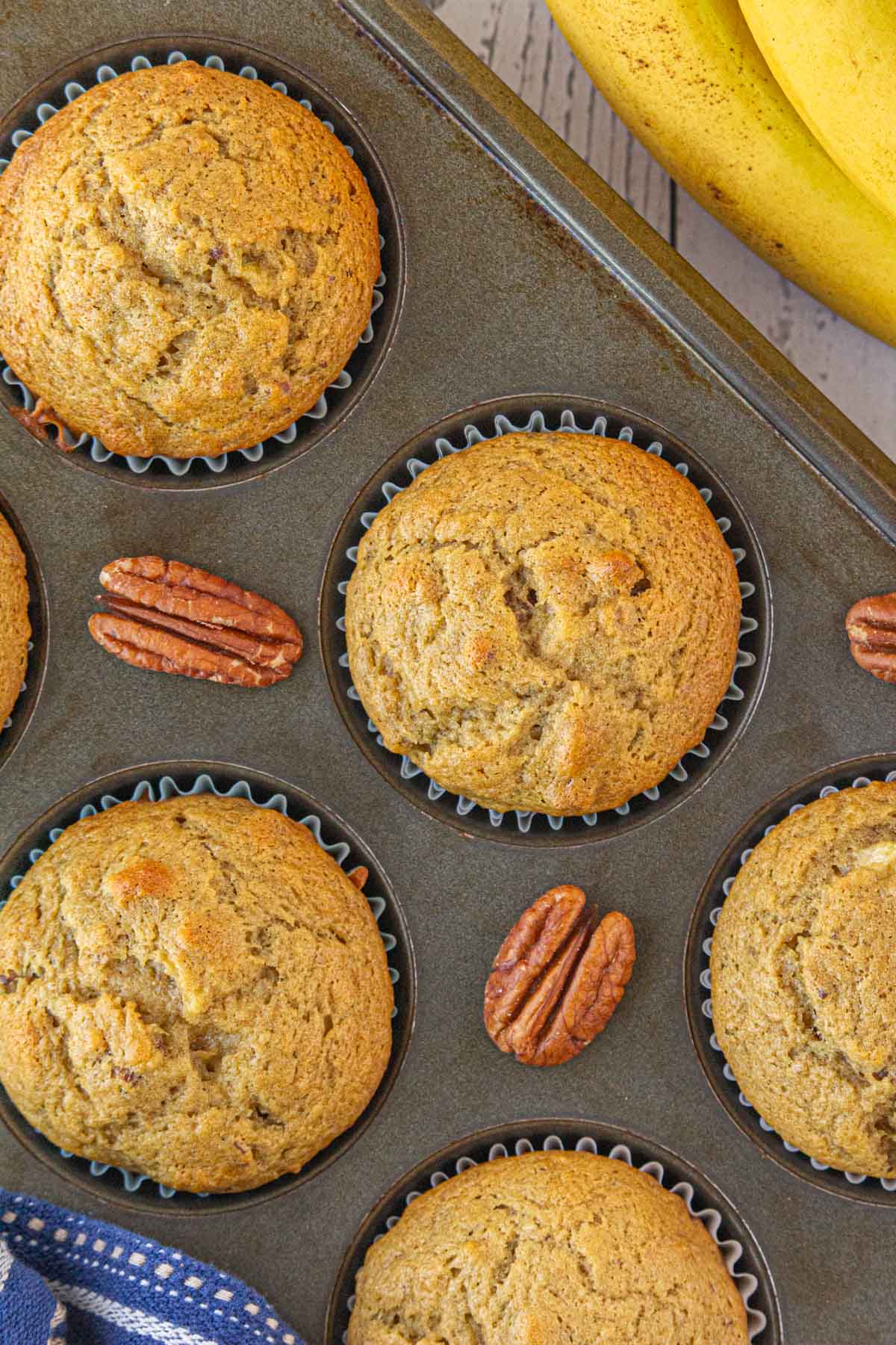 A close-up, overhead view of the brown butter banana pecan muffins in a muffin tin.