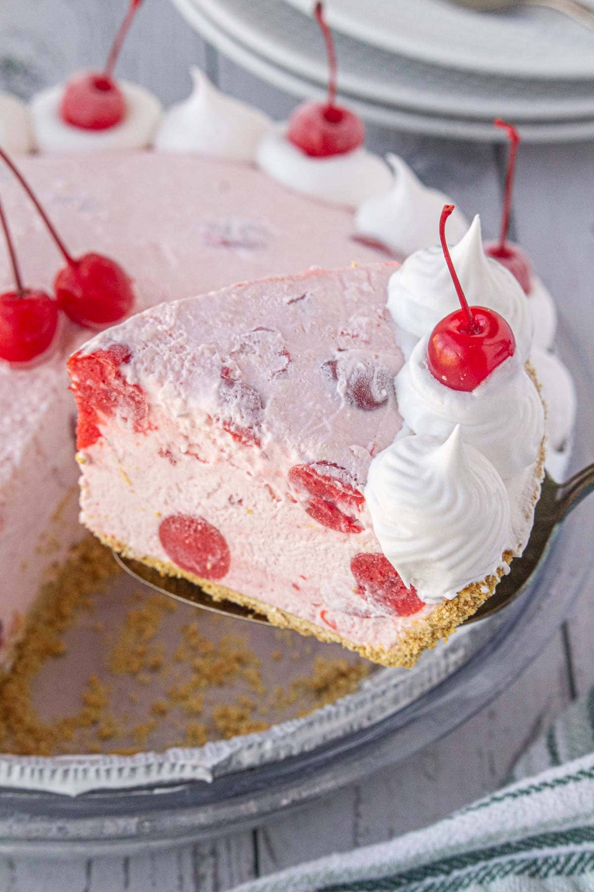 An angled view of a slice of cherry icebox pie on a pie server.