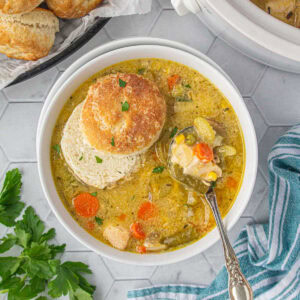 Overhead view of chicken pot pie soup recipe with a sliced biscuit floating on top.