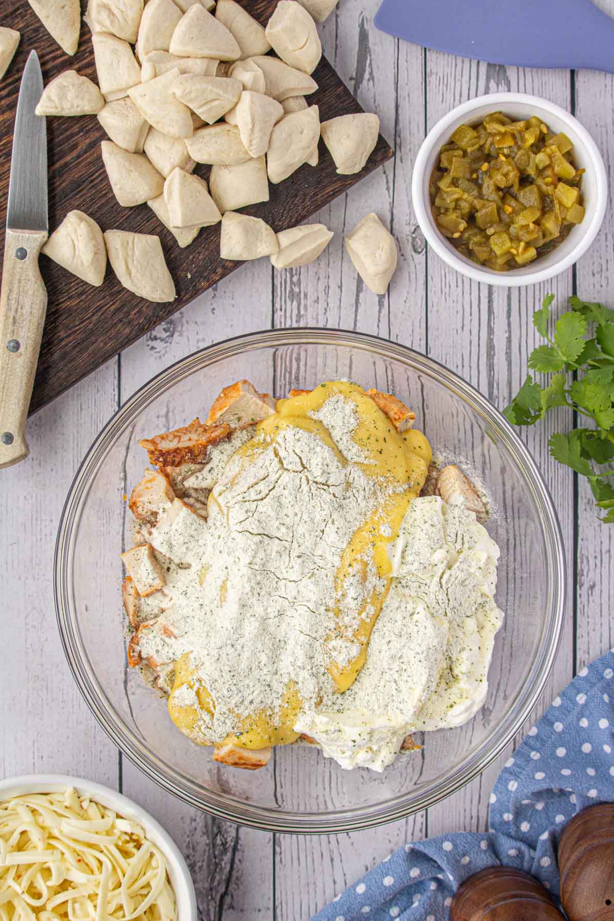 The chicken, condensed soup, Ranch mix, and sour cream in a bowl.