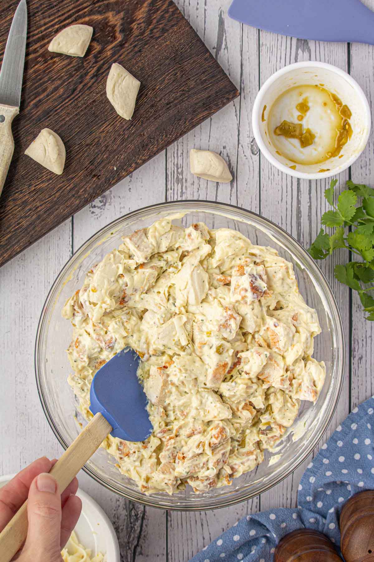 Combining the biscuit pieces with the chile chicken casserole ingredients.