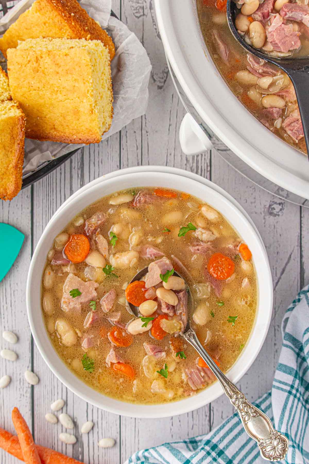 Slow cooker ham and bean soup in a dinner bowl with a spoon.