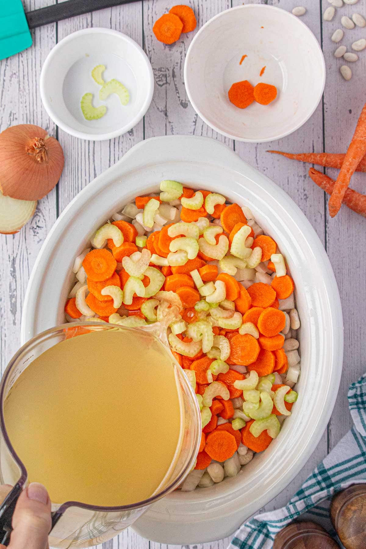 Pouring the stock over the vegetables.